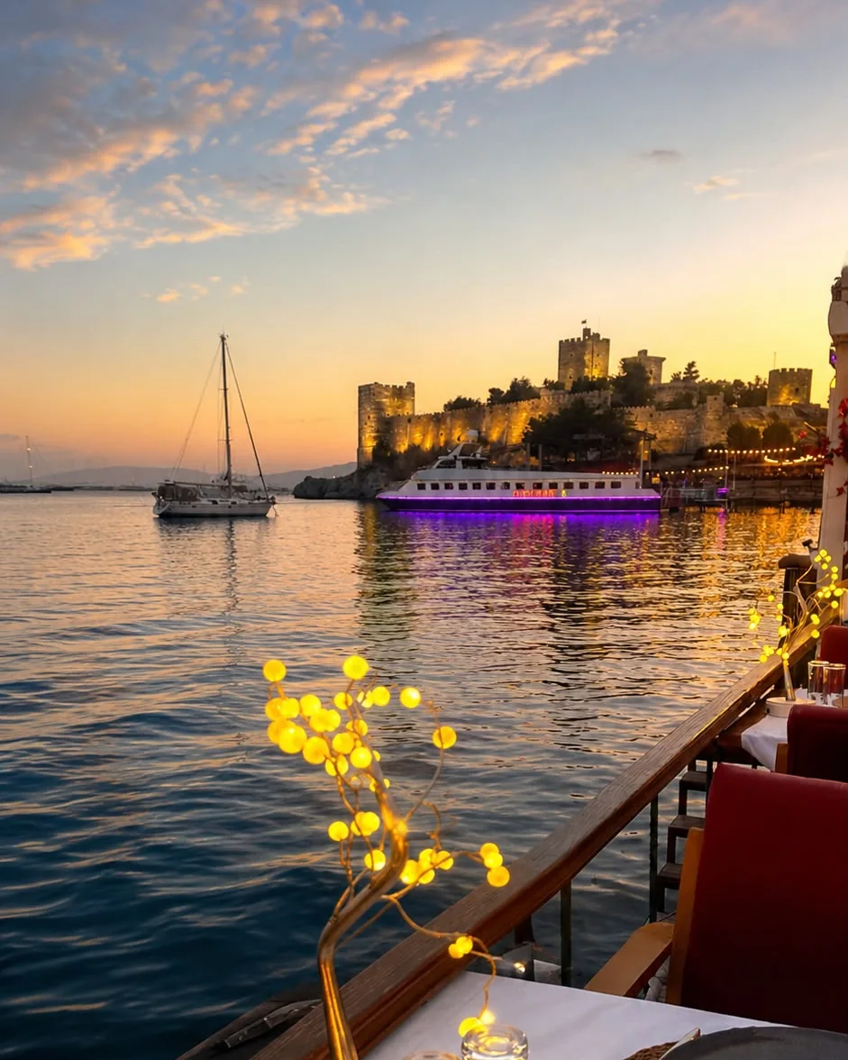 Yalı Çapkını Bodrum'dan gün batımında Bodrum Kalesi manzarası ve denize sıfır masa